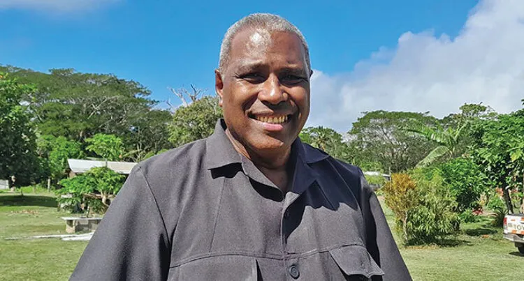 A photo of Justice Siromi Turaga standing in front of trees and plants on Koro Island