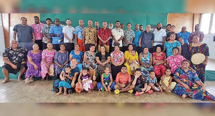 A photograph of Fijian journalists standing alongside the Fijian community living in Niue and smiling.