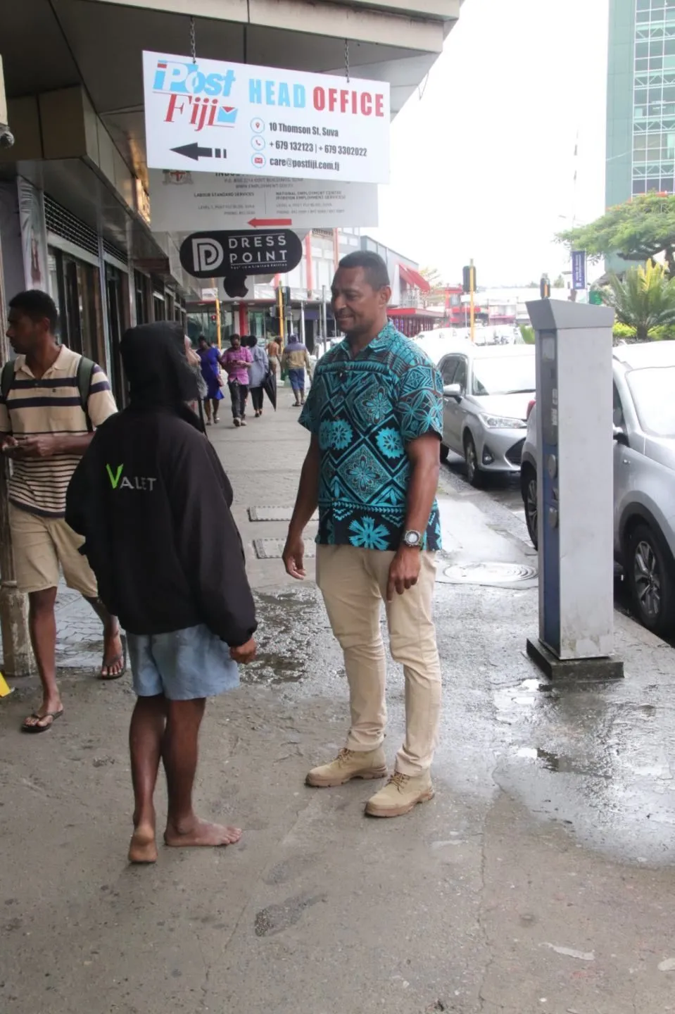 Mataiasi speaking to a shoe shiner.
