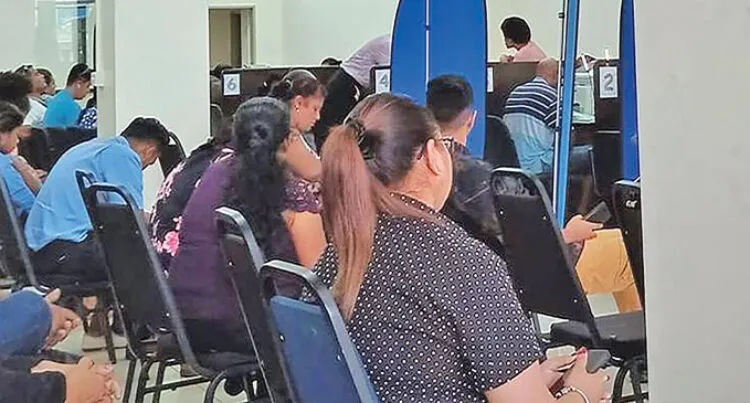 A photograph of applicants sitting in chairs and waiting to have applications and inquiries addressed at the Department of Immigration