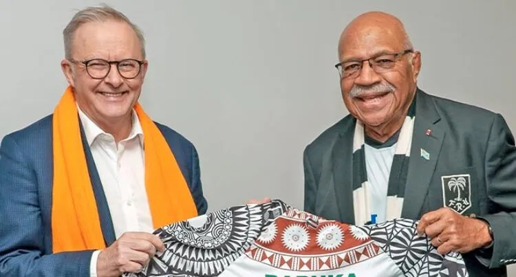 The Fijian and Australian prime ministers standing side by side and smiling. 